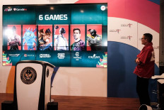 Sandiaga Uno stands beside a screen showing the six games to be contended in the 14th World Esports Championship 2022.
