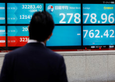 A man looks at an electronic board displaying Japan's Nikkei index outside a brokerage in Tokyo on Aug. 29, 2022.