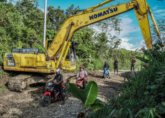 Residents on motorcycles pass a road being repaired in Jayapura city, Papua in June 2021. 