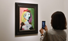 The next art hub: A woman uses a phone next to Pablo Picasso's Femme au beret rouge a pompon, 1937 during the Frieze Seoul 2022 art fair in Seoul on Friday. 