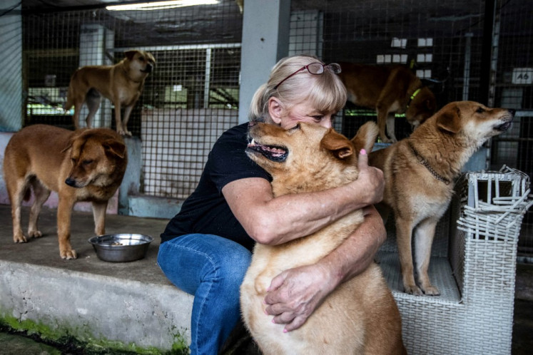A woman hugging a dog in a shelter