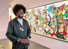 South African artist Blessing Ngobeni poses in front of his work during a show at South Africa's Joburg Art Fair, a leading contemporary art exhibition featuring artists from across the African continent, in Sandton, South Africa, September 3, 2022