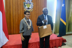 Foreign Minister Retno LP Marsudi delivers a gift to Solomon Islands Prime Minister Manasseh Sogavare during a meeting at the country's capital Honiara on Sept. 7.