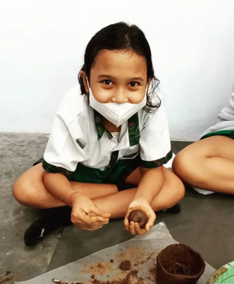 Bright smile: A happy participant handles clay during a terracotta workshop held by Kelompok Seni Gotong Royong. (Courtesy of KSGR)