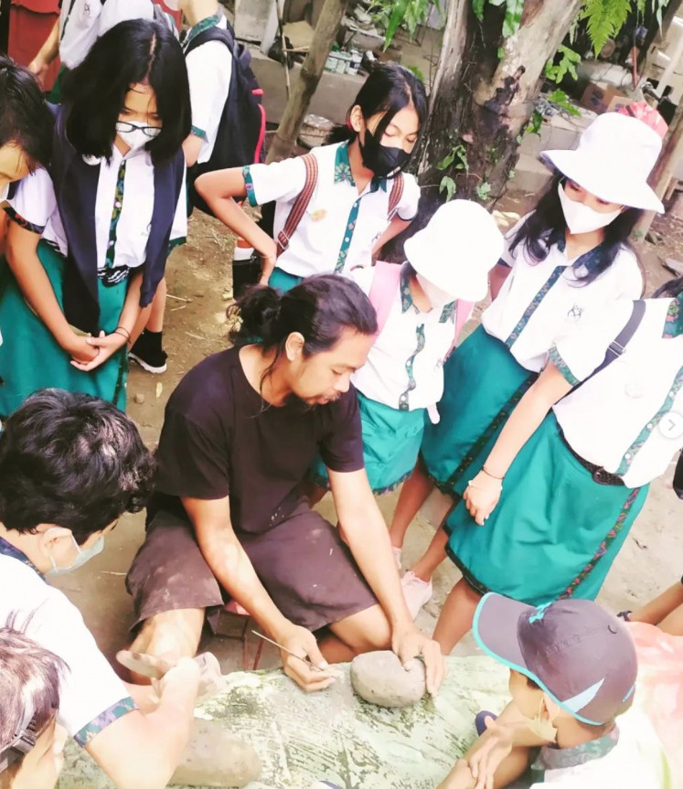 Sharing knowledge: Rio Saren, cofounder of Kelompok Seni Gotong Royong, shares his skills to some students of Bali Hati School. (Courtesy of KSGR) 