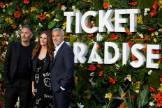 British director Ol Parker, US actress Julia Roberts and US actor George Clooney pose on the red carpet upon arrival to attend the World Premiere of the film 