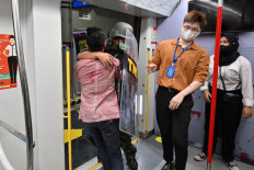 ‘Train to Jakarta’: Actors (left) play the parts of a zombie attacking a soldier onboard a car of the Jakarta LRT on Sunday, as part of the Train to Apocalypse event intended to encourage commuters to ride the city’s transit system.