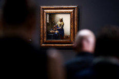 Underneath the painting: Pictured is The Milkmaid by Johannes Vermeer during a press conference on new discoveries made on one of Vermeer’s most-famous paintings at the Rijksmuseum in Amsterdam.