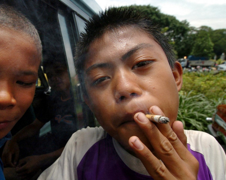 Young market: An Indonesian boy smokes a cigarette in a public area in Jakarta, on Feb. 28, 2005. (AFP/Bay Ismoyo)