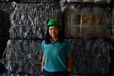 This picture taken on August 5, 2022 shows Dian Kurniawati, CEO and founder of Tridi Oasis Group, posing for photographs at a plastics recycling factory in Tangerang, Banten province. As the country's capital grapples with overflowing plastic waste and pollution pouring into the sea, a woman-led company is trying to turn its problems into opportunities through recycling.