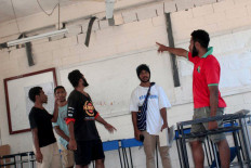 This handout photo taken and received on September 11, 2022 courtesy of WanNaiks Gallery shows people looking at the damage in a room at Wawin National High School near the city of Lae following a 7.6-magnitude earthquake off Papua New Guinea's coast. 