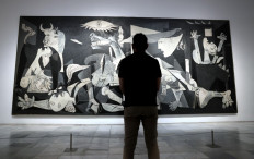 Artistic legacy: A visitor looks at Spanish painter Pablo Picasso's masterpiece Guernica during a press conference presenting the Year of Picasso events, marking the 50th anniversary of the painter's death, at the Reina Sofia museum in Madrid on Sept. 12. 