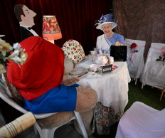 A life size cardboard cut out of Queen Elizabeth II with Paddington Bear seated at a table for tea is on display at the Rose Tree Cottage English Tea Room in Pasadena, California, following the death of the Queen on September 8, 2022. 