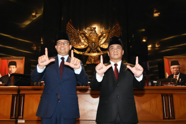 Jakarta Governor Anies Baswedan (left) and his deputy Ahmad Riza Patria (right) pose for photographers on Sept. 13, 2022 after attending a plenary session at the Jakarta City Council. The session formally declared the end of the governor and deputy governor’s terms in October.