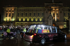 The coffin of Queen Elizabeth II arrives in the Royal Hearse at Buckingham Palace in London on September 13, 2022, where it will rest in the Palace's Bow Room overnight. Queen Elizabeth II's coffin will on Tuesday be flown by the Royal Air Force from Edinburgh to London, accompanied by the queen's only daughter Anne, the Princess Royal, and driven to Buckingham Palace, to rest in the Bow Room.
