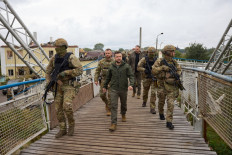 This handout picture taken and released by Ukrainian Presidential press-service on September 14, 2022 shows Ukrainian President Volodymyr Zelensky (center) walking during his visit to de-occupied city of Izyum, Kharkiv region.
