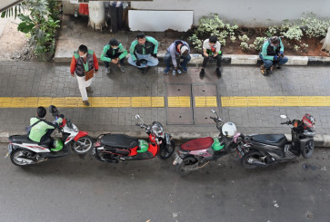 Drivers of ride-hailing services Gojek and Grab wait for passengers in Jakarta on June 24, 2020. 
