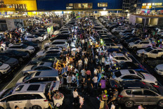 People sell items from the trunks of their cars at a market located in a parking lot in Shenyang in China's northeastern Liaoning province, on July 2, 2022.
