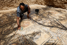 Palestinian farmer Salman al-Nabahin cleans a mosaic floor he discovered at his farm and which dates back to the Byzantine era, according to officials, in the central Gaza Strip September 18, 2022.