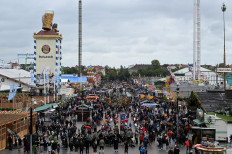 Participants of the traditional costume parade of the Oktoberfest beer festival arrive at the Theresienwiese fair grounds in Munich, southern Germany, on September 18, 2022. The world renowned Beer festival is taking place from September 17 to October 3, 2022 without access restrictions, after the past two years' editions had been cancelled due to the coronavirus pandemic.
