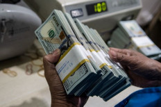Every banknote counts: A teller counts Unites States dollar banknotes at Bank Mandiri’s cash pooling in Jakarta.