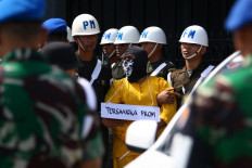 Military police escort a suspect for a crime reconstruction in Mimika on September 3, 2022, after he and five other  soldiers have been accused of killing four indigenous Papuans and mutilating their bodies last week. 