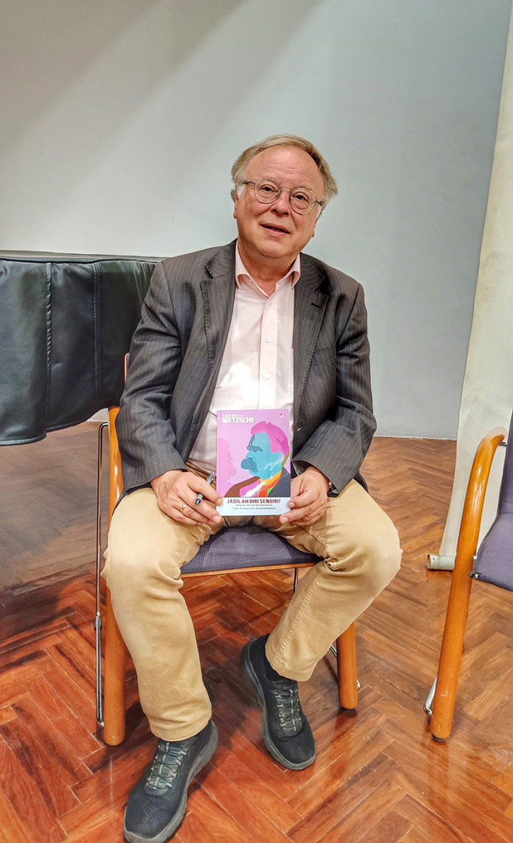 Get to know the author: Berthold Damshauser poses with his book “Jadilah Diri Sendiri!  Kumpulan Aforisme dan Kata Mutiara Friedrich Nietzsche' after an interview.  (JP/Sylviana Hamdani) 