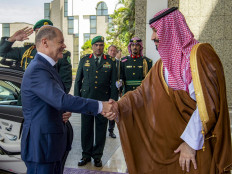 This handout picture provided by the Saudi Royal Palace shows (right to left) Saudi Crown Prince Mohammad bin Salman shaking hands with Germany's Chancellor Olaf Scholz at al-Salam Palace in the Red Sea coastal city of Jeddah on September 24, 2022. 