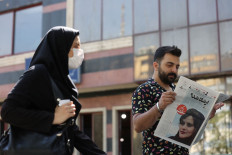Making the headline: A man views a newspaper with a cover picture of Mahsa Amini, a woman who died after being arrested by the Islamic Republic's 