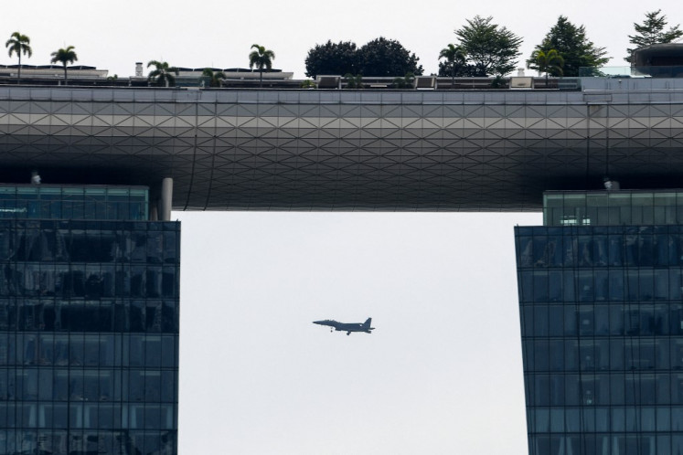 A Republic of Singapore Air Force fighter jet flies past the Marina Bay Sands hotels and resorts tower in Singapore on September 30, 2020.
