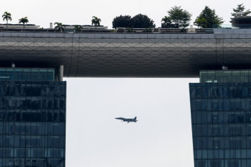 A Republic of Singapore Air Force fighter jet flies past the Marina Bay Sands hotels and resorts tower in Singapore on September 30, 2020.
