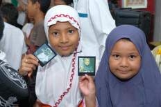 The happiness of two children of Kuntum Teratai orphanage holding their instant photos. 
