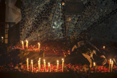Candles and flower petals are pictured during a vigil by the residents and football supporters outside the Kanjuruhan stadium in Malang, East Java on October 2, 2022.