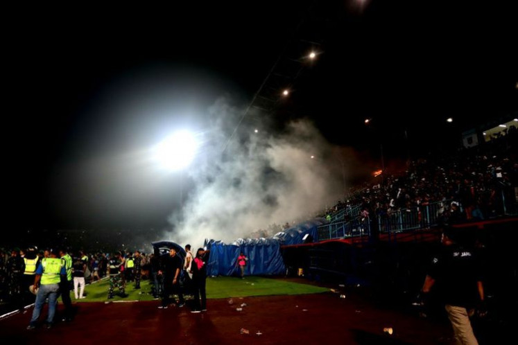 National tragedy: Plumes of tear gas hang over the stands at the Arema FC-Persebaya Surabaya match at Kanjuruhan Staidum on Saturday.(Kompas.com/Suci Rahayu)
