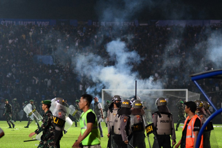 This picture taken on Oct. 1, 2022 shows tear gas released by police among people crowded in the stands after a football match between Arema FC and Persebaya at the Kanjuruhan stadium in Malang, East Java. 
