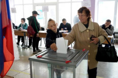 Casting doubt: A woman casts her ballot for a referendum at a polling station in Mariupol, Ukraine, on Sept. 27. Many nations, including Indonesia, have described the referendums in Kremlin-controlled regions of eastern and southern Ukraine as violating international laws. 
