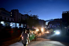 Commuters make their way along a street during a power blackout in Dhaka on October 4, 2022. At least 130 million people in Bangladesh were left without power on October 4 after a grid failure caused widespread blackouts, the government's power utility company said.
