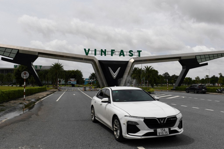 A Vinfast car drives past the entrance of the VinFast electric automobile plant in Haiphong on Aug. 26, 2022. Having conquered most industries at home, optimistic chiefs at conglomerate Vingroup are setting their sights much higher as they ramp up plans to sell the first ever Vietnamese car in the mighty United States market.
