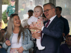 Australian Prime Minister Anthony Albanese holds 1-year-old Capria Thompson while speaking with families of victims before a memorial service to mark the 20th anniversary of the Bali bombings, which killed 202 people including 88 Australians, at Coogee Beach in Sydney, Australia, October 12, 2022. 