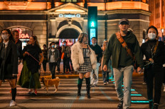 People cross a street on The Bund in Shanghai, China, on Oct. 12, 2022.