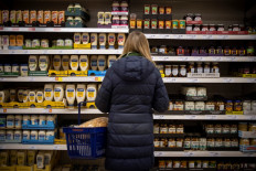 Customers shop for chilled juices at a Sainsbury's supermarket in Walthamstow, east London on February 13, 2022. UK annual inflation struck 5.4 percent in December, stoking fears of a cost-of-living squeeze as wages fail to keep pace.
