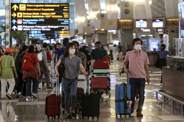 Passengers walk past check-in counters on Oct. 18, 2022, in Terminal 3 at Soekarno-Hatta International Airport in Tangerang, Banten.