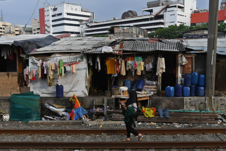 A woman walks on a railroad track running by a slum in Kampung Bandan, Central Jakarta, on Oct. 14, 2022. Statistics Indonesia (BPS) reported that Jakarta’s poverty rate in March 2022 had increased since September 2021 by 3,750 to reach 502,040 people, or 4.69 percent of the city’s population.