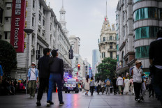 People walk on a street in Shanghai, China, on  Oct. 16, 2022.