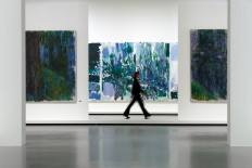 This photograph taken on September 29, 2022 shows French painter Claude Monet's (left and right) and an American artist Joan Mitchell's paintings (center) exposed at “Monet - Mitchell“ exhibition which will be open from October 5, 2022 to February 27, 2023 at the Fondation Louis Vuitton in Paris. 
