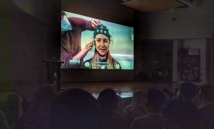 Movie screening: An excerpt of the film  'Nine-and-a-Half - Your  Reporters: Unimaginable! What Thoughts Can Move’ (2021), in which Jana, the reporter, experiments with an EEG cap to move things without touching them. (JP/Sylviana Hamdani)