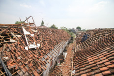 Residents repair the roof of a house damaged by strong winds in Sidokepung village, Sidoarjo, East Java, on Oct. 24.