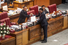 Done deal: Deputy House of Representatives Speaker Lodewijk F Paulus (left) receives the final draft of the personal data protection law from Communications and Information Minister Johnny G. Plate during a plenary session on Sept. 20. The House unanimously passed the bill into law.