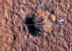 This handout image courtesy of NASA/JPL-Caltech/University of Arizona obtained on October 27, 2022 shows the impact crater, formed on December 24, 2021, by a meteoroid strike in the Amazonis Planitia region of Mars, is about 490 feet (150 meters) across, as seen in this annotated image taken by the High-Resolution Imaging Science Experiment (HiRISE camera) aboard NASA's Mars Reconnaissance Orbiter. 
