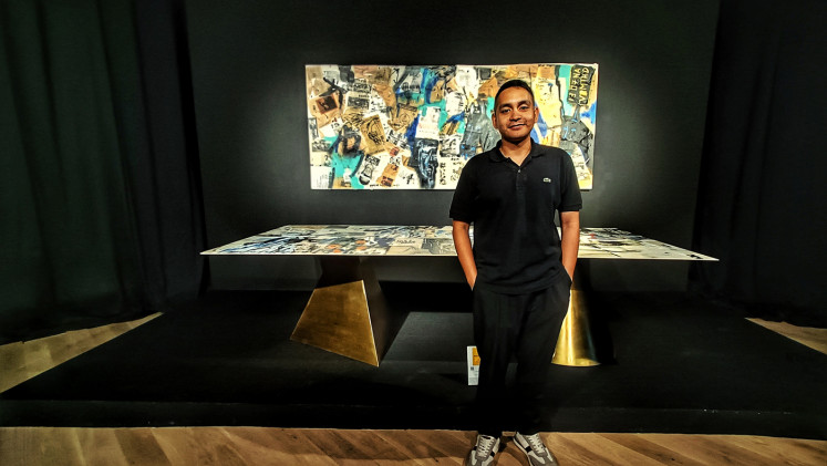 Emerging artist: Naufal Abshar poses in front of his dining table titled 'Diversity of Stories' at the Timeless Creativity: A Different Kind of Canvas exhibition held at Senayan City, Jakarta, until Nov. 4. (JP/Sylviana Hamdani)
